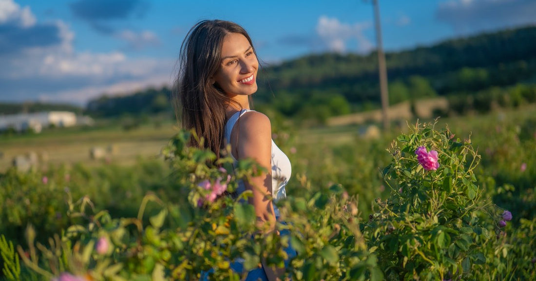 Donna in un campo di rose in fiore nella Valle delle Rose bulgara