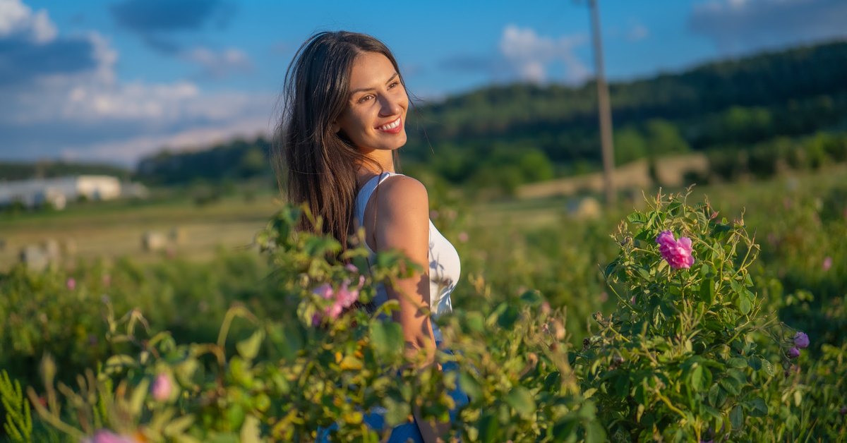Donna in un campo di rose in fiore nella Valle delle Rose bulgara
